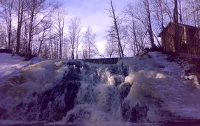 Frozen waterfall and hut forester