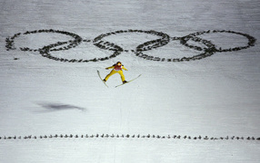 Спортсмен на фоне Олимпийских колец на Олимпиаде в Сочи