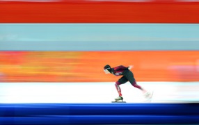 Скоростной бег на коньках на фоне стены на Олимпиаде в Сочи