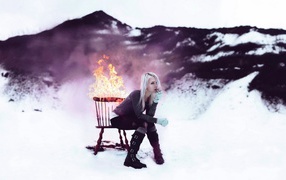 Девушка сидит на горящем стуле