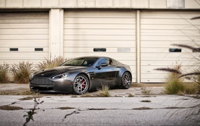 Черный Aston Martin в ворот белого ангара