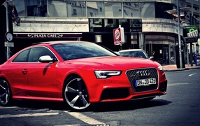 Red Audi RS5 at a sidewalk cafe