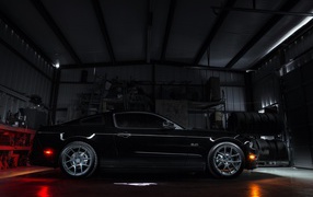 Черный спортивный Ford Mustang в гараже