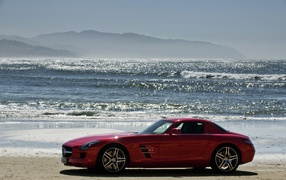 Red Mercedes on beach sand