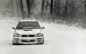Покрытый снегом Subaru Impreza на зимней дороге
