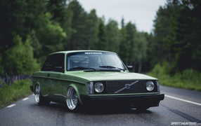 Green Volvo 240 on the road
