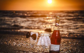 Бутылка вина и два бокала на пляже
