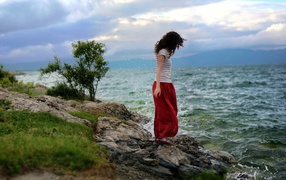 Девушка с кучерявыми волосами на берегу моря