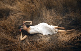 Girl lying on the dry grass