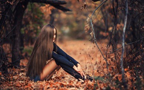 Girl sitting on a fall foliage
