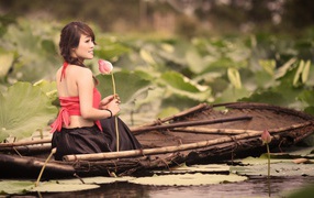 Девушка с цветком сидит в лодке