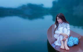 Японская девушка сидит в лодке на озере