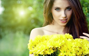 Long-haired girl with a bouquet of yellow wildflowers