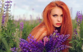 Длинноволосая рыжая девушка в поле лаванды