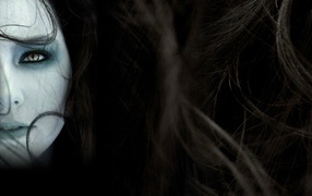 The girl's face among the hair on a dark background