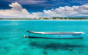 Белая лодка на голубой прозрачной воде