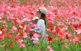 A girl with a baby is on the field of flowers