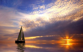 Sailing boat in the calm sea at sunset