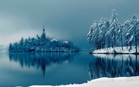 Snow-covered island with a church in the middle of the lake