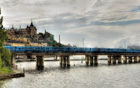 Поезд пересекает мост над рекой в Швеции