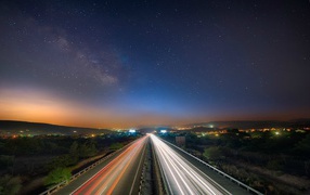 Night traffic on the highway under the stars
