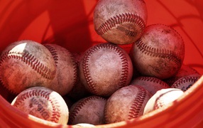 Red bucket of balls for baseball