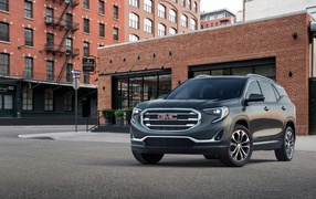 Gray SUV GMC Terrain on the background of the building