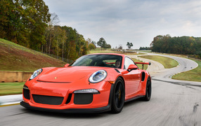 Оранжевый спортивный автомобиль Porsche 911 GT3 на трассе