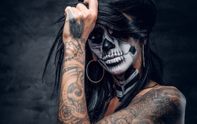 Brunette with tattoos and makeup on her face
