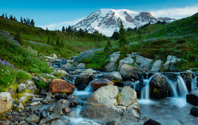 A picturesque stream flows through the rocks against the backdrop of the mountain