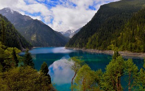 Красивое озеро у покрытых лесом гор в парке Цзючжайгоу, Китай