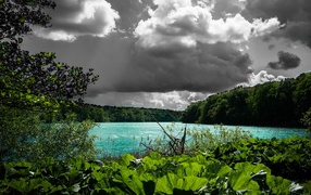 Голубая вода в озере на фоне дождевых облаков 