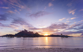 Lilac sunset in the sky above the ocean, the island of Bora Bora.