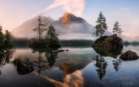 Mountain lake at the mist-covered mountains