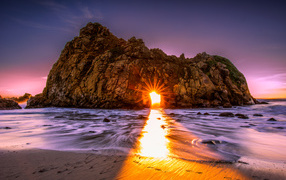 Sun rays make their way through the hole in the rock Pfeiffer Beach Big Sur, California