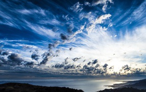 Красивое покрытое облаками небо на береговой линией моря