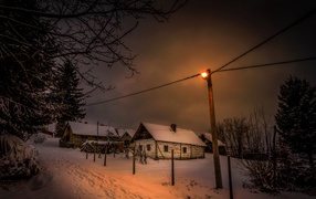 Snow-covered houses on a winter street at night