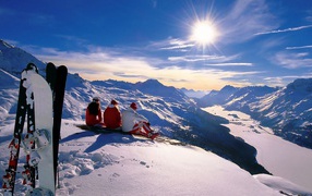 Snowboarders meet the dawn in the snowy mountains