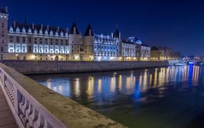 Night lights of the Conciergerie Castle in the river, Paris. France