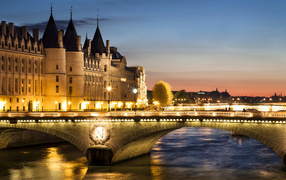 The bridge in the light of the night lights at the former royal castle Conciergerie, Paris. France