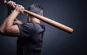 Athlete baseball player with a bat in his hand on a gray background photo