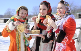 Three young beautiful girls with pancakes at the Pancake week