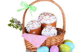 Easter cakes in a basket with dyed eggs on a white background