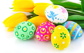 Painted eggs with a bouquet of yellow tulips on a white background for Easter