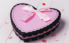 A large heart shaped gift box with a pink bow