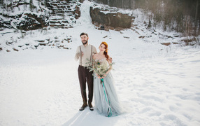 A loving couple of newlyweds standing in the snow