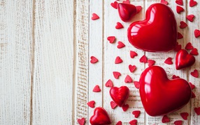 Большие и маленькие  красные  сердечки на деревянном фоне