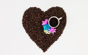 Heart made of coffee beans with a cup on a white background