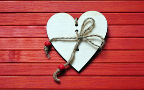 Heart with a rope on a red wooden background