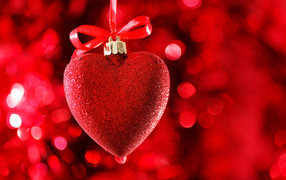 Red big shiny heart with ribbon on red background